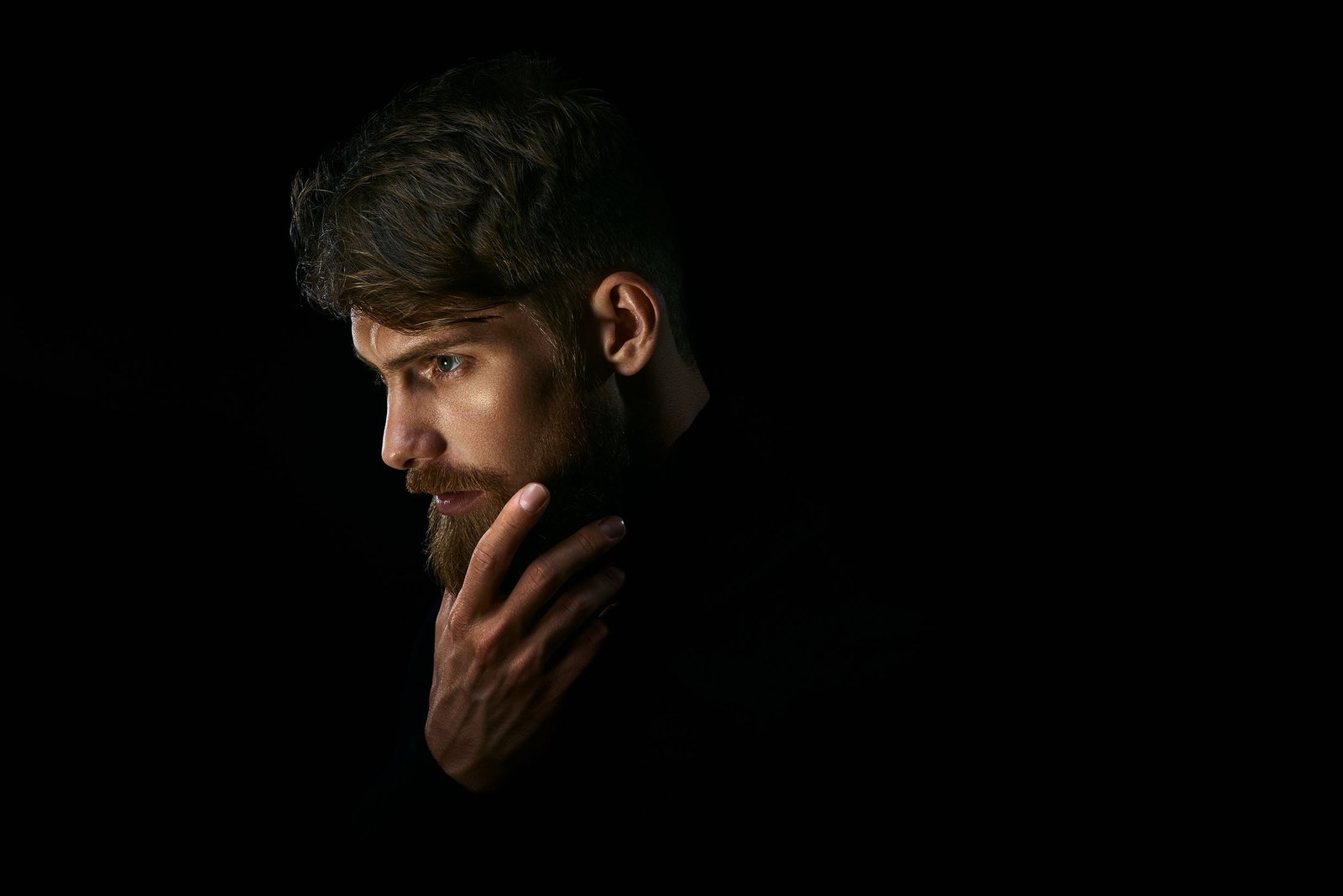 Side portrait of a man against a black background